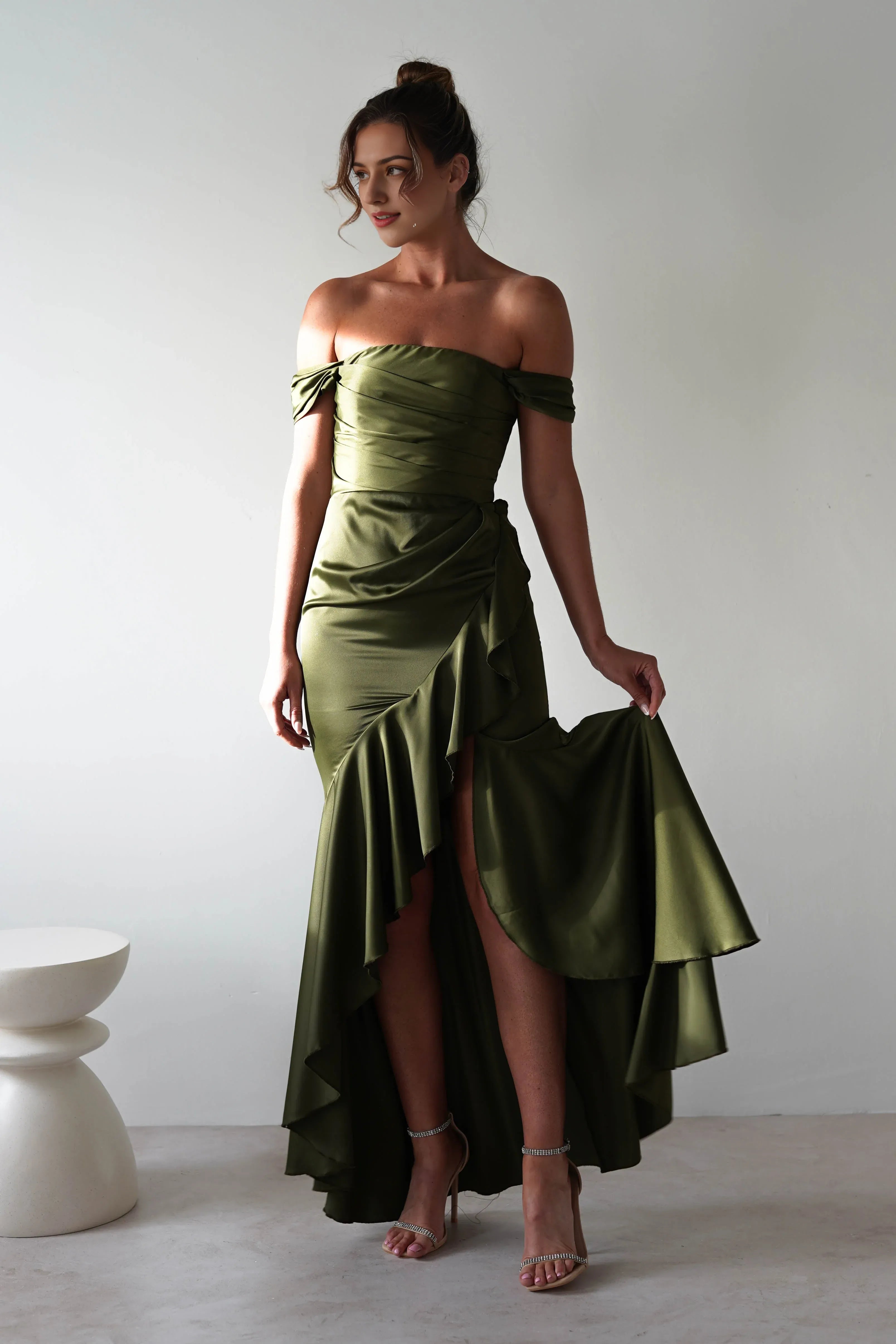 Vestido Weitese de satén verde oliva con escote en V, corpiño fruncido, falda asimétrica y dobladillo hasta el suelo.